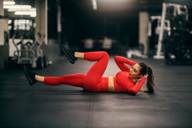 istock A sportswoman is doing bicycle crunches at the gym. 2158125105