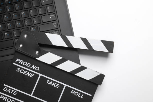 istock Laptop with a clapperboard on a blue background. Top view 2158125890