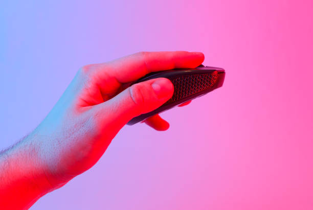 Hand holding Wireless black pc mouse in blue-pink gradient neon light