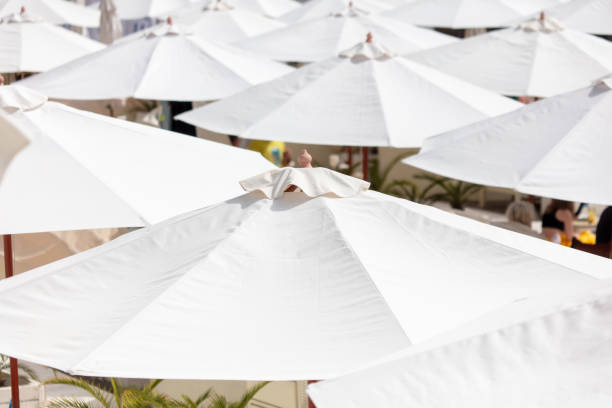 White umbrellas on the beach by the sea.