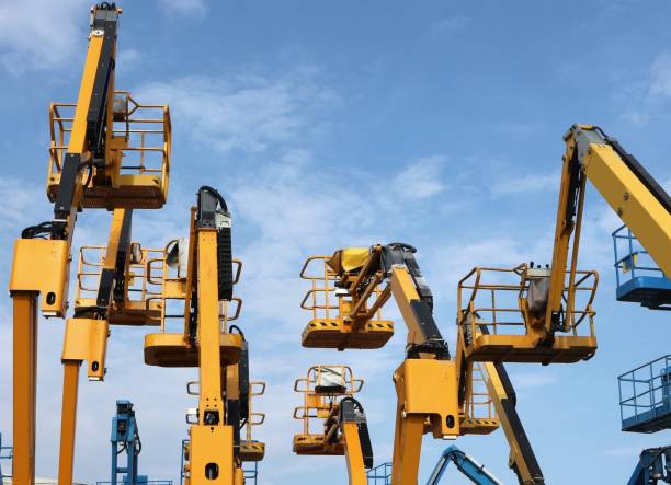 istock Rear view of many work platforms of cherry pickers in a row. 2158127294