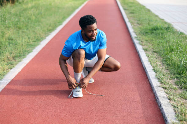 istock Young man tying his shoelaces 2158127520
