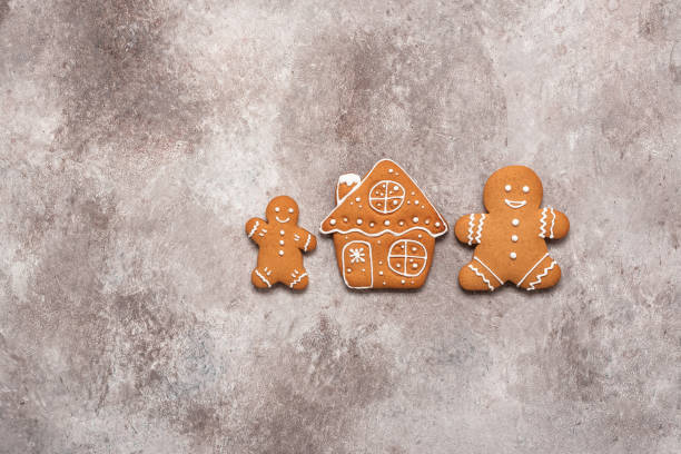 istock Gingerbread man and house in line on a brown background. Top view, flat lay. 2158128940