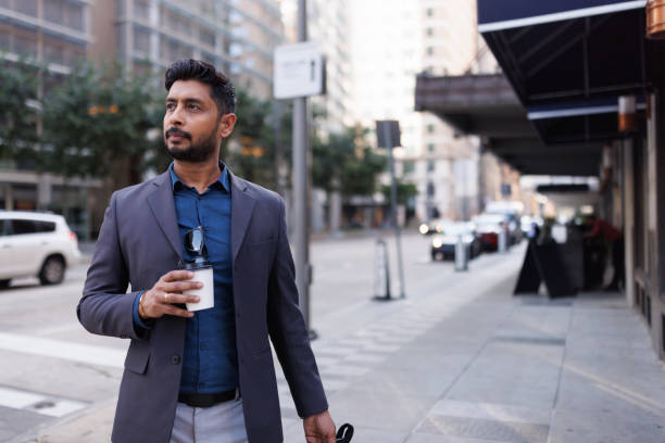 istock Businessman walking around the city while drinking takeaway coffee 2158129293
