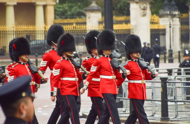 roop of royal guards marching in close-up on textured pavement with dramatic shadows in London, England, UK