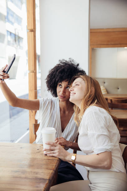 istock Two young businesswomen taking a break in a cafe. 2158130904