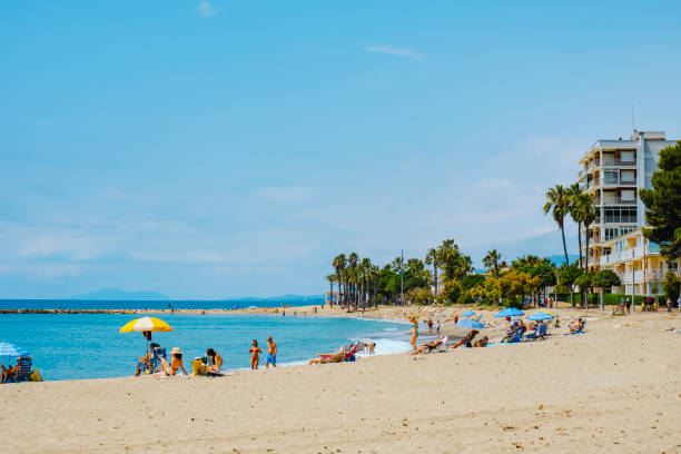 Cambrils, Spain - June 9, 2024: People enjoying the weather of a sunny spring day at Ardiaca Beach in Cambrils, Spain, in the very popular Costa Dorada coast, in the Mediterranean sea