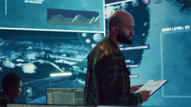 istock Army officer examining real time satellite data on big screen in military base 2158133136