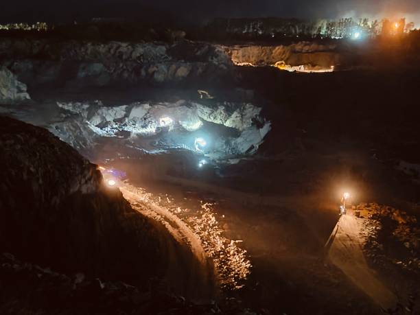 istock Excavation mining deep earth in the dusty illuminated lights of dark night 2158134826