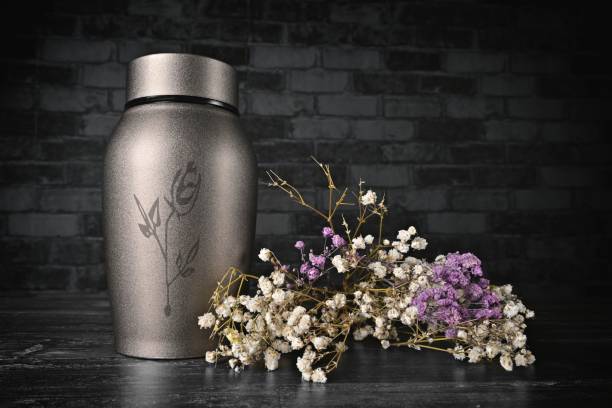 istock Cremation urn next to a bunch of flowers. 2158137904