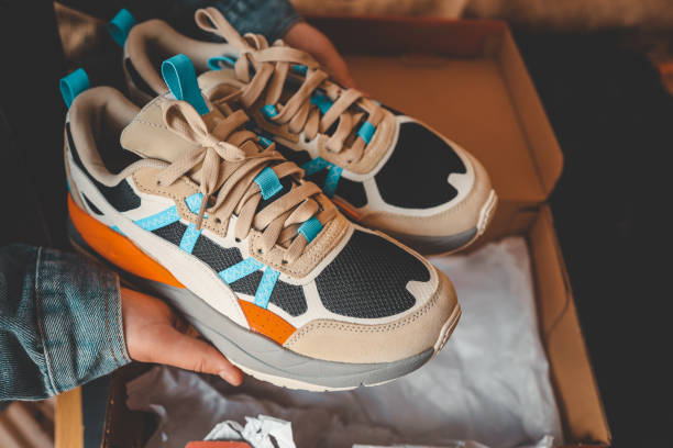 istock Men's sneakers in hands, unpacking stylish shoes 2158141549