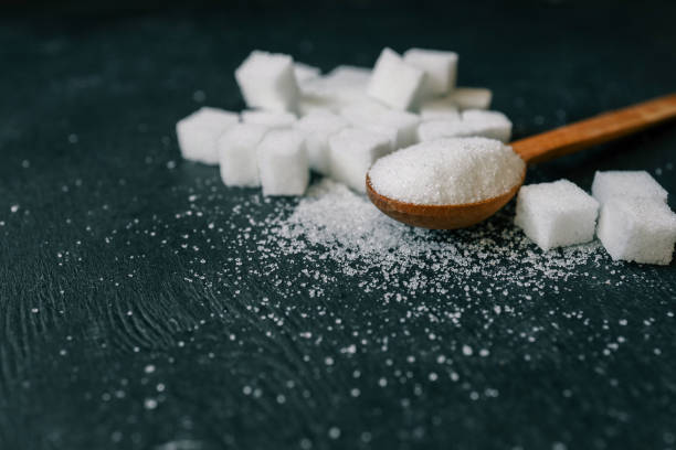 istock White crystalline sugar cubes on a wooden spoon 2158143827