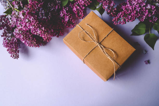 istock Gift box with bow and a bouquet of lilacs, top view 2158144475