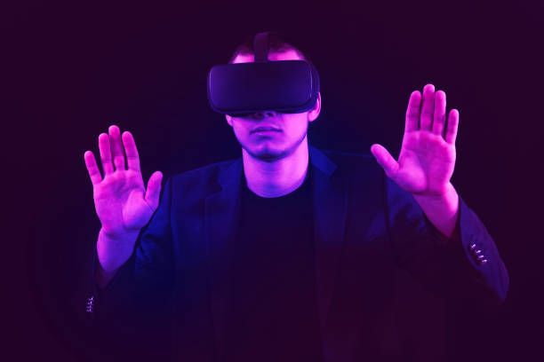 istock Virtual reality game male plays using virtual reality glasses. It has purple and blue light streaks. Retro Style. 2158154185