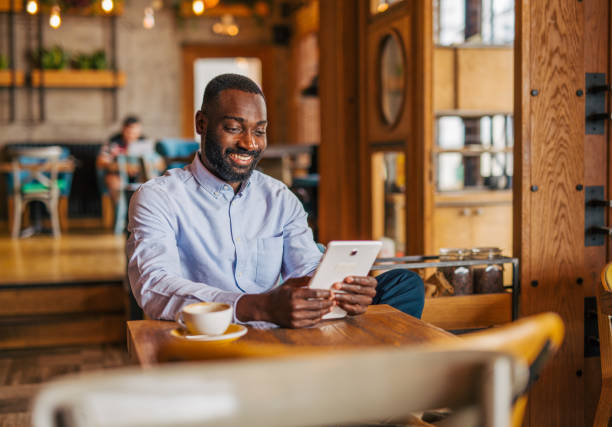 istock an adult handsome black male in cafe using tablet 2158156150
