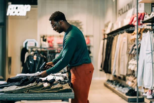 istock Happy retail clerk working at a clothing store 2158156586
