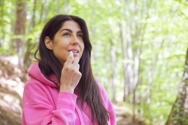 istock Young woman  protecting lips with lip balm 2158157578