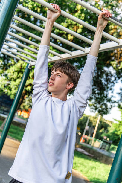 istock Young Man Exercising on Monkey Bars in Park 2158158867