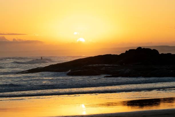 istock Stunning sunset over a rocky shoreline with waves crashing 2158160332