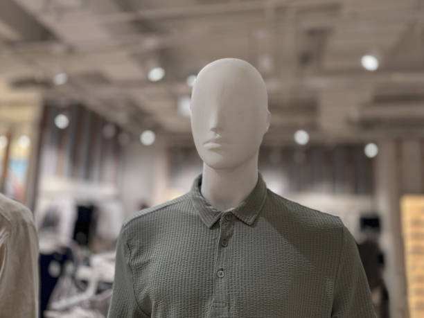 White neutral head of a mannequin figure in minimalist style on a metal stand against a light beige gray background, copy space, selected focus