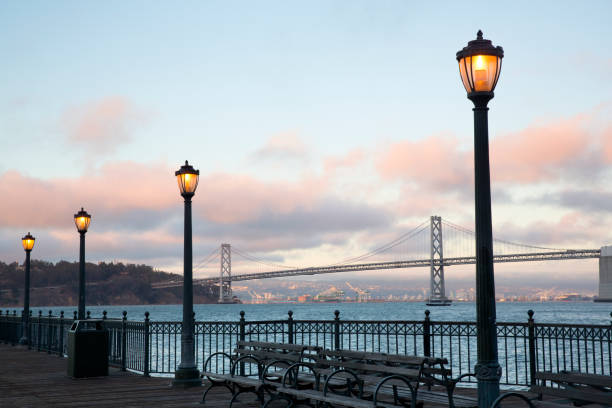 istock Street lamps illuminate pier at dusk 2158162673