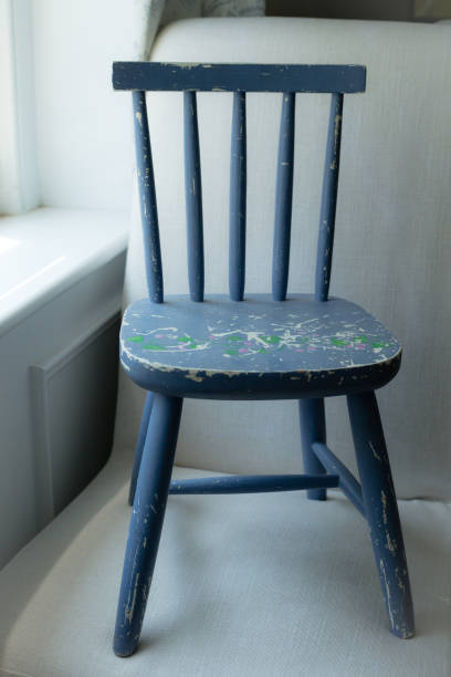 A blue wooden chair and a rope winding iron on the blue painted floor of the ferry