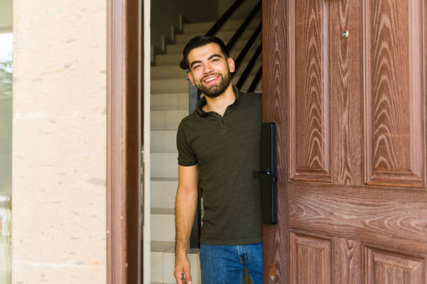 Man greets guests with a warm smile at his front door, creating a welcoming atmosphere