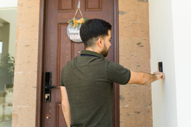 istock Young man using a smart doorbell while visiting a friend during the day 2158163068