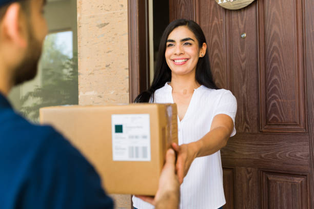 istock Woman joyfully accepting a delivery from a courier at her doorstep 2158163963