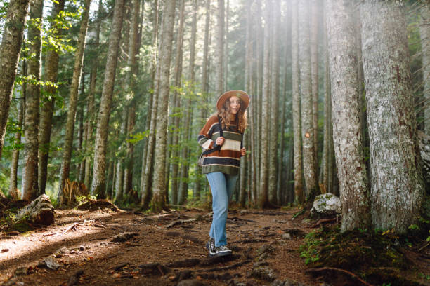 istock Young female traveler with backpack walking in national park or forest. 2158168610