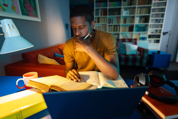 istock African American student studies at home at night 2158170484