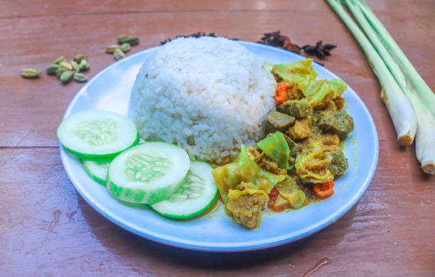 istock Beef tongseng with curry sauce, with vegetables served with rice in a white plate and garnished with spices. Beef tongseng contains pieces of cabbage, cayenne pepper, tomatoes. 2158173669