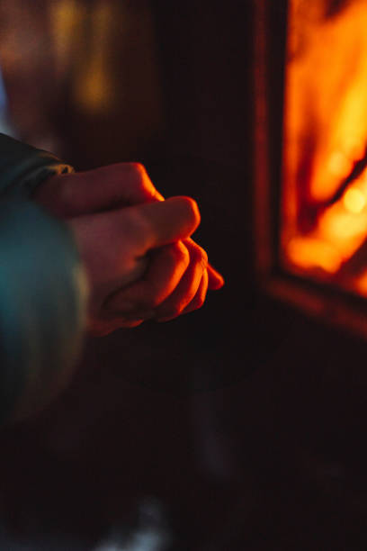 istock Woman warming up near a fireplace in a hut 2158175694
