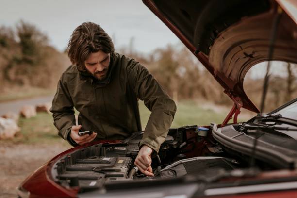 istock Man trying to fix broken car photo 2158176276