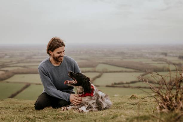 istock Man & dog sitting on hill photo 2158176404