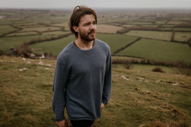 istock Man wearing long sleeve shirt, walking on hill 2158176440
