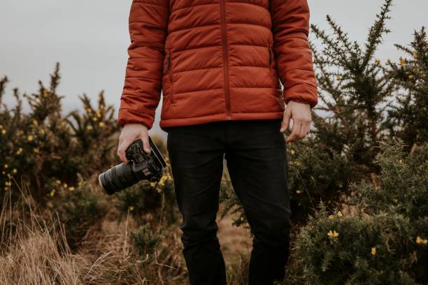 istock Photographer wearing jacket, holding camera, nature photo 2158176474