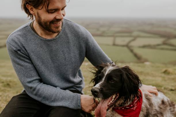 istock Man & dog sitting on hill photo 2158176497