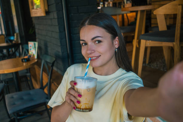 istock young woman is drinking coffee and taking a selfie 2158176692