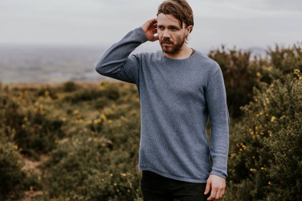 istock Man wearing long sleeve shirt, walking on hill 2158176913