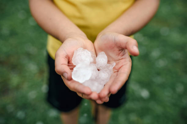 istock Hands holding quarter sized hail stones. Natural disaster concept. 2158177723