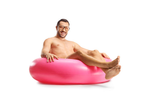 Handsome man with sunglasses sitting on a swimming ring isolated on white background