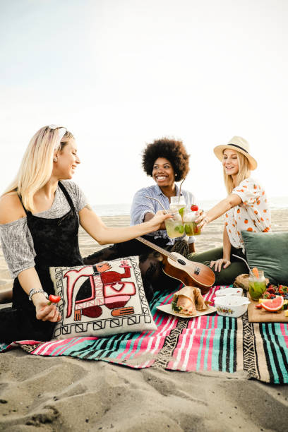 istock Friends clinking their drinks at a beach party 2158181664