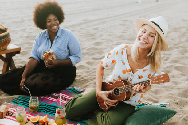 Friends singing together at a beach picnic