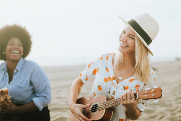 istock Friends singing together at a beach picnic 2158182108