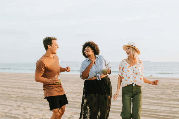 istock Friends dancing and having fun at the beach 2158182120