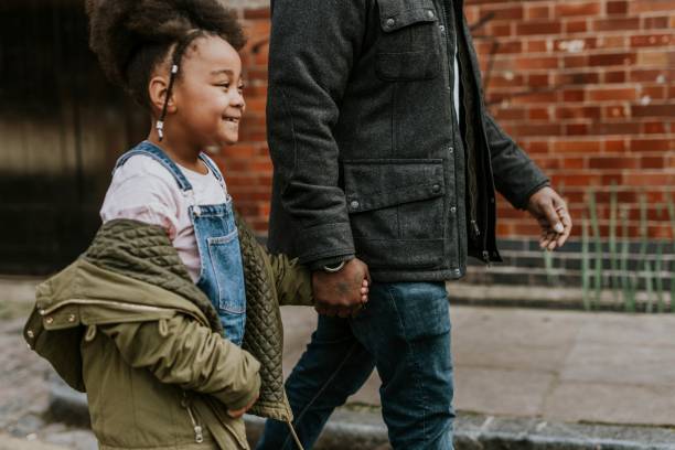 istock Daughter holding dad's hand, walking in city 2158183382