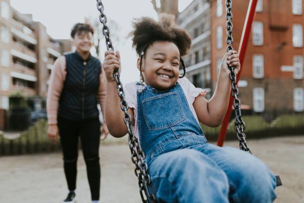 istock Happy girl sitting on swing 2158183554