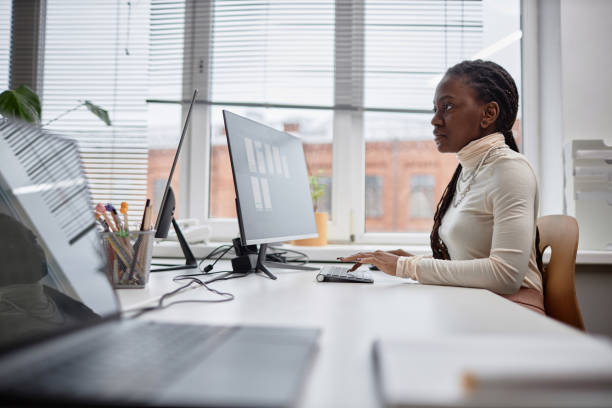 istock Concentrated Black Woman Typing on Keyboard in Office 2158183682