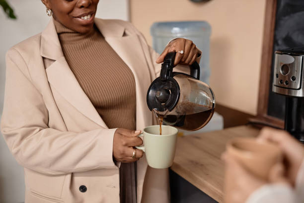 African American Woman Making Coffee in Office